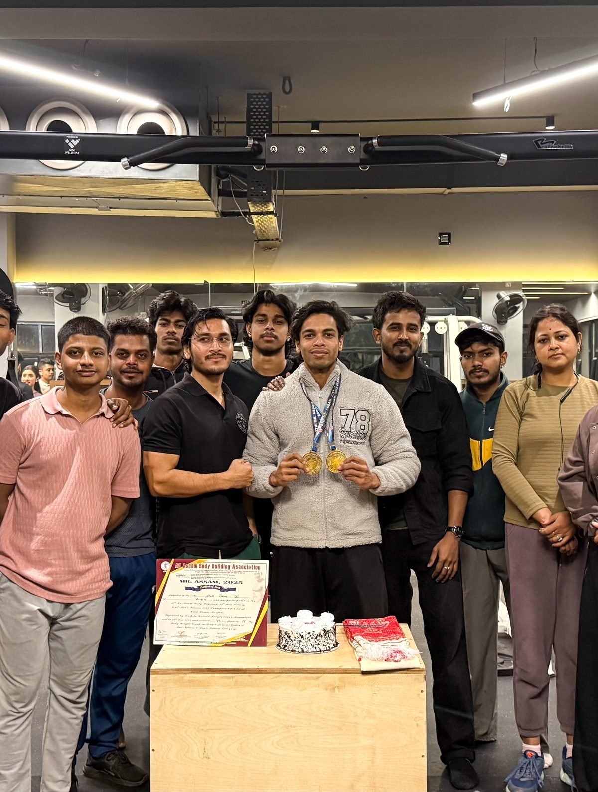 Celebrating a medal with the Muscle Mansion family